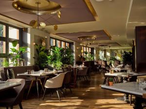 a restaurant with tables and chairs and plants at Sofitel Legend The Grand Amsterdam in Amsterdam