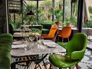 a restaurant with green chairs and tables with wine glasses at Sofitel Legend The Grand Amsterdam in Amsterdam