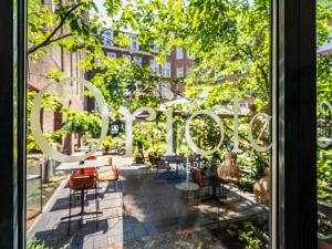 a window view of a patio with tables and chairs at Sofitel Legend The Grand Amsterdam in Amsterdam