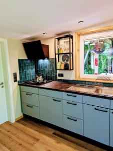 a kitchen with white cabinets and a window and a sink at Ferienhaus Bornholt in Bornholt