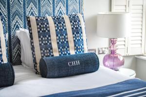 a blue and white bed with a pillow on it at Harbour Hotel & Spa Christchurch in Christchurch