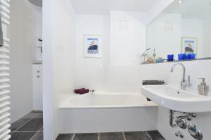ein weißes Badezimmer mit Badewanne und Waschbecken in der Unterkunft Ferienwohnung Silbermöwe in Sassnitz