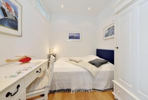 a small bedroom with a bed and a dresser at Ferienwohnung Silbermöwe in Sassnitz