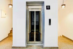 a glass door in a white building with two lights at Collection O Sector 53 Golf Course Road in Gurgaon