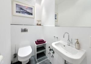 ein weißes Badezimmer mit Toilette und Waschbecken in der Unterkunft Ferienwohnung Silbermöwe in Sassnitz
