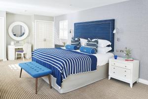 a bedroom with a blue and white bed and a desk at Harbour Hotel & Spa Christchurch in Christchurch