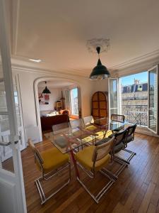 ein Esszimmer mit einem Glastisch und Stühlen in der Unterkunft Haussmannian Appartment, Charm & Unobstructed view in Paris + 2 Fotos
