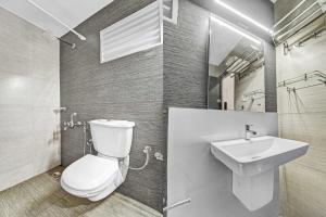 a bathroom with a toilet and a sink at Hotel O Kalady Near Airport in Kāladi