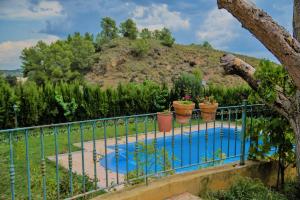 a fence with a pool in front of a mountain at Ecoagroturismo Las Nieves in Murcia
