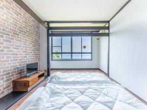 een slaapkamer met een bed en een bakstenen muur bij Villa FUN Kawana in Ito +57 foto's