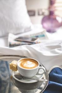 a cup of coffee and a piece of bread on a tray at Harbour Hotel & Spa Christchurch in Christchurch