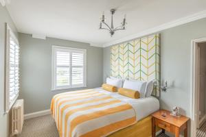 a bedroom with a large bed and a chandelier at Harbour Hotel & Spa Christchurch in Christchurch