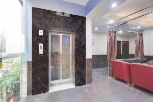 a room with a glass door and red chairs at Collection O Maithli Marg Sector 55 Noida in Indirapuram