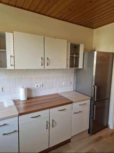 a kitchen with white cabinets and a stainless steel refrigerator at Weilburg Apartments in Baden +6 photos