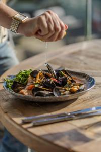 a plate of food with mussels on a table at Harbour Hotel & Spa Christchurch in Christchurch