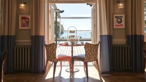 a table and chairs in a room with a window at Harbour Hotel & Spa Christchurch in Christchurch
