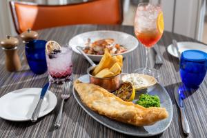 a table with a plate of food and drinks at Harbour Hotel & Spa Christchurch in Christchurch