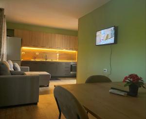 a living room with a table and a kitchen at EverGreen Escape in Berat in Berat