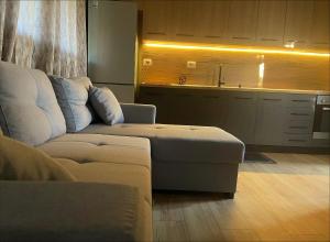 a living room with a couch and a kitchen at EverGreen Escape in Berat in Berat