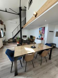 a dining room with a wooden table and chairs at Escapade Blésoise Chambres-Appart-Loft and Spa-Jacuzzi in Blois