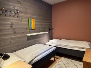 deux lits dans une chambre avec un mur de briques dans l'établissement Riddertunets atmosfære, à Beitostøl