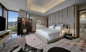 Postel nebo postele na pokoji v ubytování Swissôtel Nusantara