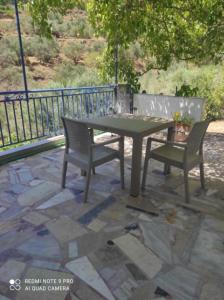 a picnic table and two chairs on a patio at Valentino's Apartment 2 in Panormos Kalymnos +7 photos