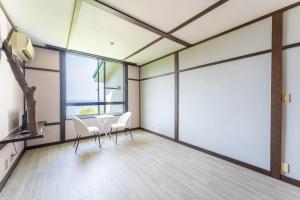 a room with two chairs and a table and windows at Villa FUN Kawana in Ito +54 photos