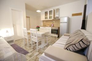 une cuisine et une salle à manger avec une table et un réfrigérateur dans l'établissement Studio Apartment Laura, à Zadar