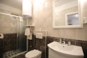 une salle de bain avec un lavabo, des toilettes et un miroir dans l'établissement Studio Apartment Laura, à Zadar 14 autres photos