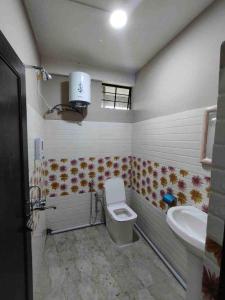 a bathroom with a toilet and a sink at Arara Ans Homestay in Cherrapunji