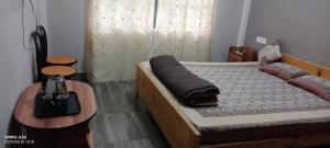 a bedroom with a bed and two tables and a bed sidx sidx sidx at Arara Ans Homestay in Cherrapunji