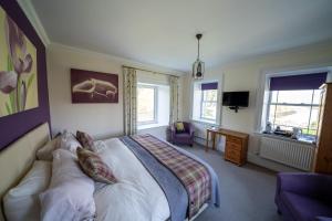 a bedroom with a bed and a couch in it at Two Harbours Guest House in Scalpay