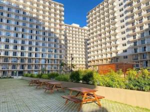 eine Reihe von Picknicktischen vor zwei großen Gebäuden in der Unterkunft Bellvoir Luxe in Suba