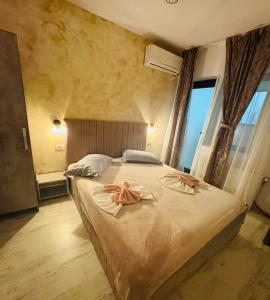 a bedroom with a large bed with two towels on it at Ama Boutique in Constanţa
