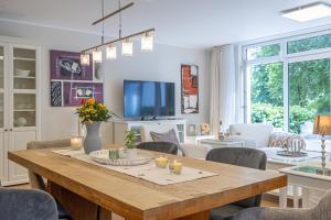 Una sala de estar con una mesa de comedor con sillas. en fewo1846 - Residence Museumsberg - luxuriöse Wohnung mit 2 Schlafzimmern und 2 Bädern, en Flensburg