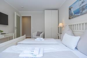 1 dormitorio blanco con 1 cama blanca y 1 silla en fewo1846 - Residence Museumsberg - luxuriöse Wohnung mit 2 Schlafzimmern und 2 Bädern, en Flensburg