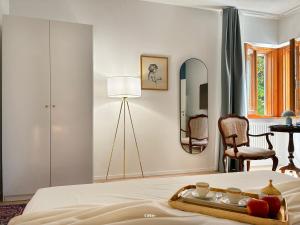 a bedroom with a bed with a mirror and a chair at Villa Radici in Teramo