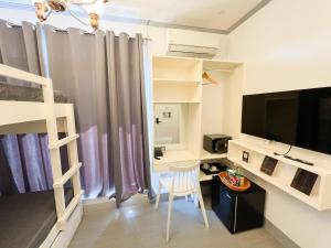 a small room with a desk and a bunk bed at Ronina's Sipocot Hotel in Sipocot