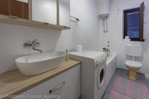 a bathroom with a sink and a washing machine at Gato in Novalja