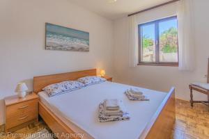 a bedroom with a large bed with towels on it at Gato in Novalja