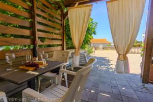 a table and chairs on a patio with curtains at Gato in Novalja +53 photos