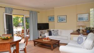 a living room with white furniture and a television at La Molina Casa in Calera