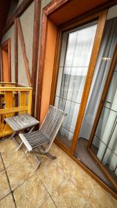 una silla sentada en un porche junto a una ventana en Apartmán Katka, en Veľká Lomnica