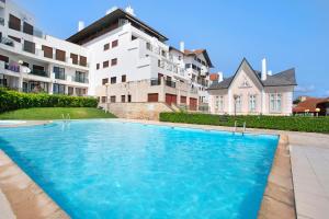 a large swimming pool in front of a building at Apartamento Vista Baia in São Martinho do Porto