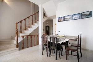 a dining room with a table and chairs and stairs at Apartamento Vista Baia in São Martinho do Porto