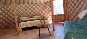 a bedroom with a bed in a yurt with a table at Yourte in Aouste-sur-Sye