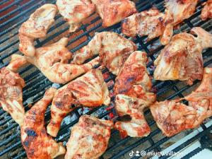 a bunch of chicken and other food on a grill at Miugu Village Hotel in Murangʼa