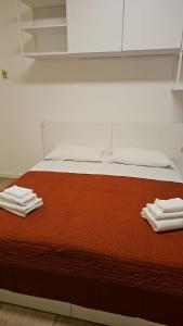 a bed with two towels on top of it at Locami Bi-Apartments Padova in Padova