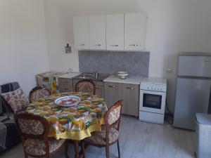 a kitchen with a table and chairs and a refrigerator at Casa di SaleRosa in Rilievo